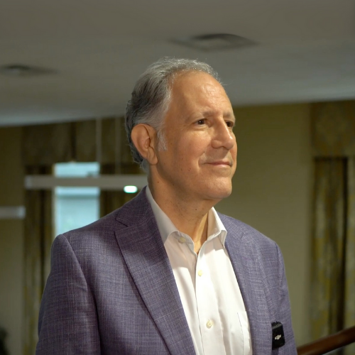 Dr. Howard Cohen looks off camera wearing a suit.