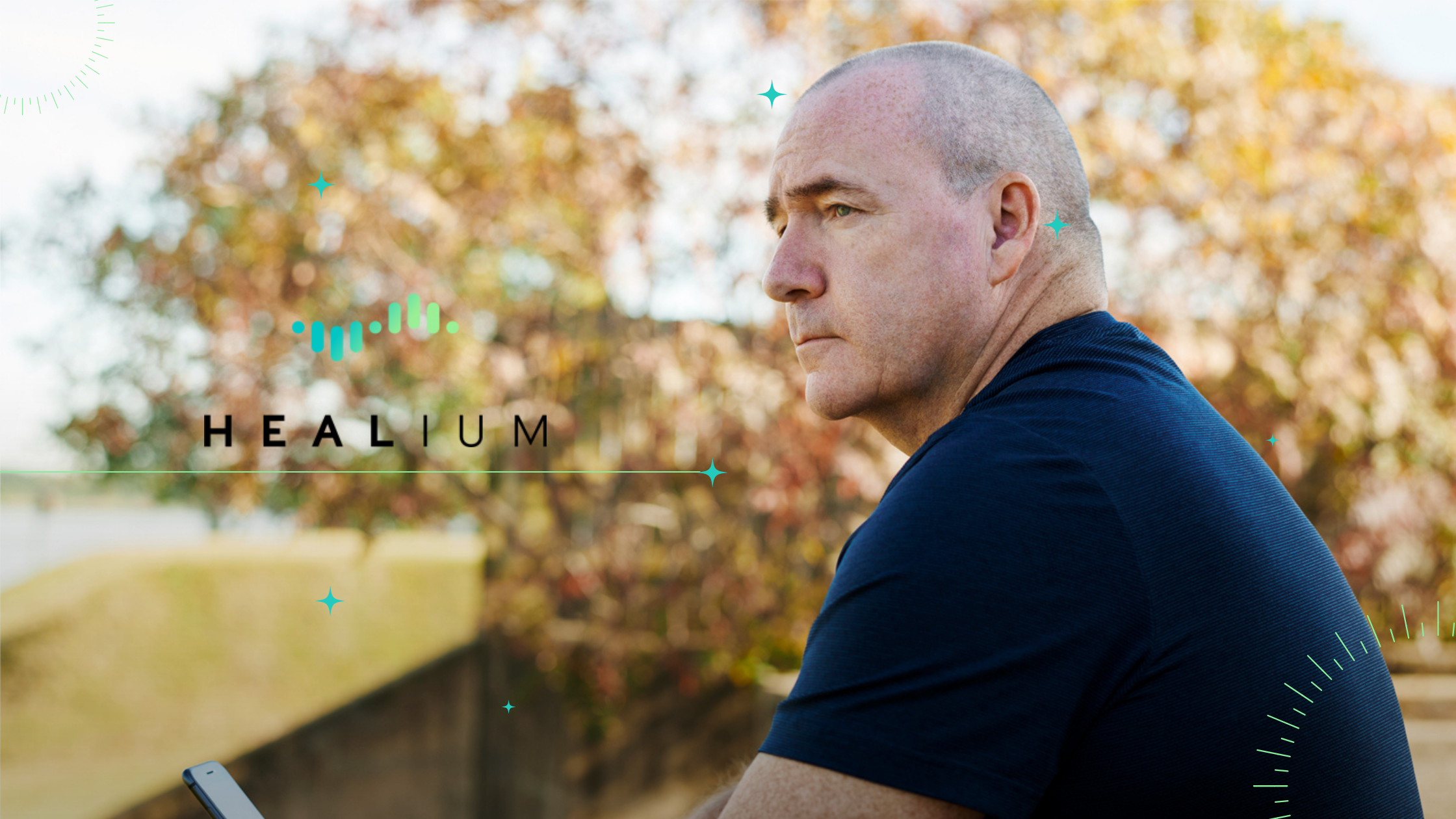 A man outside looking retrospective. The Healium logo is to his middle left.